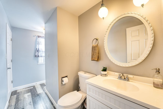 bathroom featuring toilet, wood-type flooring, and vanity