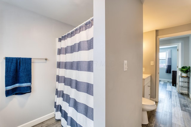 bathroom featuring toilet, walk in shower, wood-type flooring, and vanity