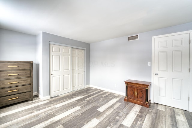 unfurnished bedroom featuring a closet and hardwood / wood-style flooring