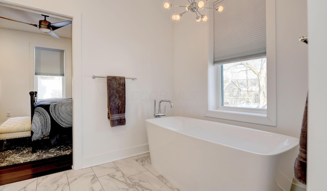 bathroom featuring a bath, ceiling fan with notable chandelier, and plenty of natural light