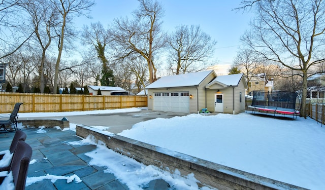 snow covered garage with a trampoline