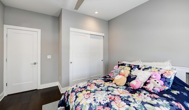 bedroom featuring ceiling fan, a closet, and dark hardwood / wood-style flooring