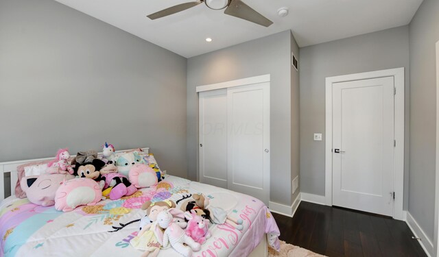 bedroom with ceiling fan, dark hardwood / wood-style flooring, and a closet