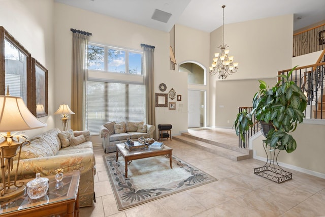 living area with stairs, a high ceiling, baseboards, and a notable chandelier