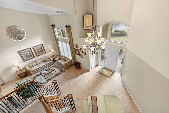 living room featuring a high ceiling, plenty of natural light, visible vents, and an inviting chandelier