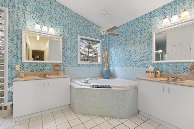 bathroom featuring tile walls, two vanities, tile patterned floors, vaulted ceiling, and a sink