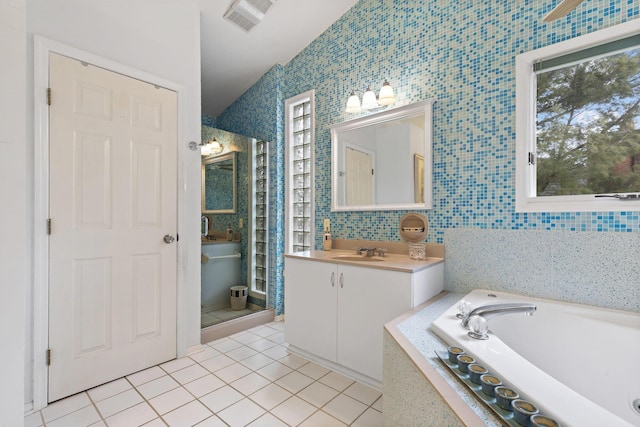 bathroom featuring a bath, visible vents, tile walls, and tile patterned floors