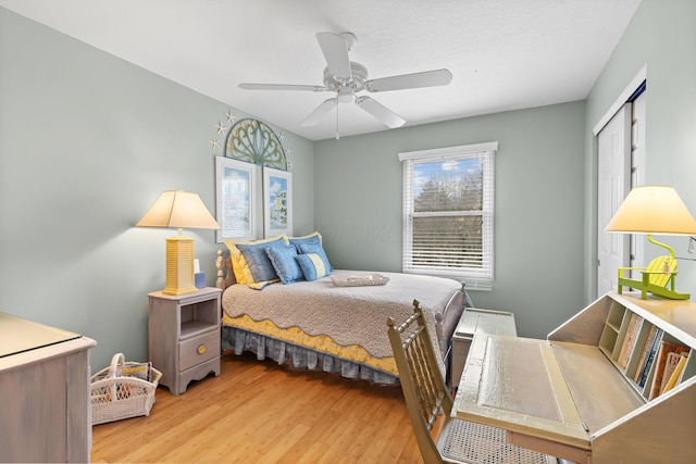 bedroom with a closet, wood finished floors, and a ceiling fan