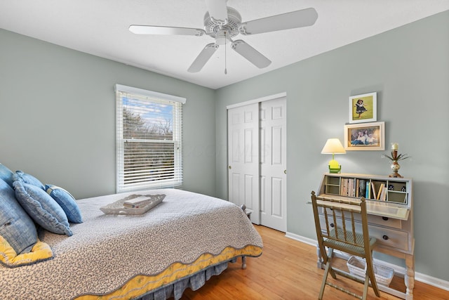 bedroom featuring a closet, ceiling fan, baseboards, and wood finished floors