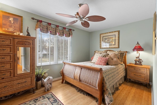 bedroom featuring light wood-type flooring, baseboards, and a ceiling fan