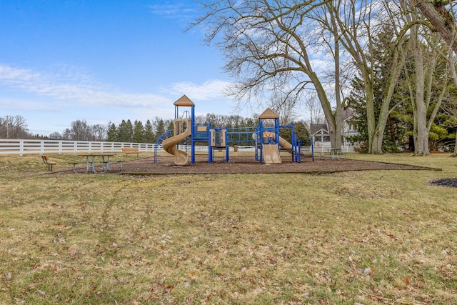 community play area with a lawn and fence