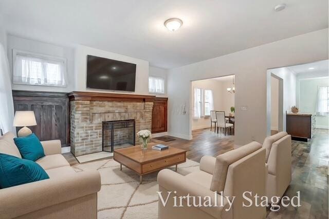 living room featuring light hardwood / wood-style flooring and a stone fireplace