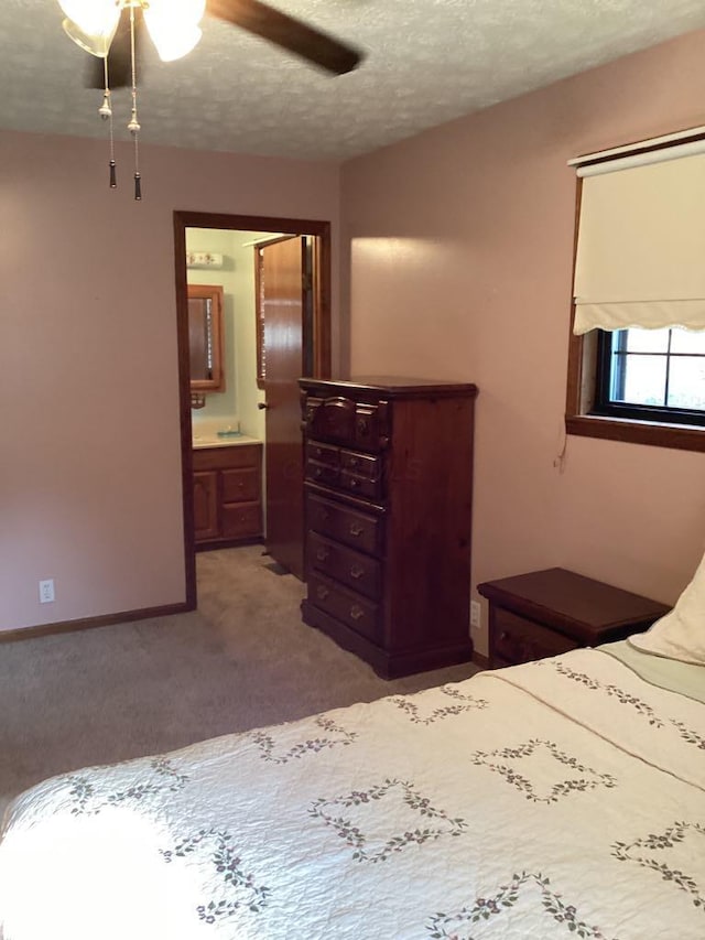 unfurnished bedroom with light carpet, ceiling fan, a textured ceiling, and ensuite bath