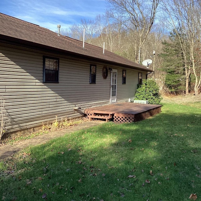 back of property featuring a deck and a yard