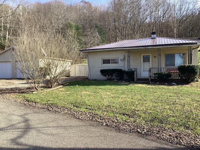 view of front of property with covered porch, a front yard, a garage, and a storage unit