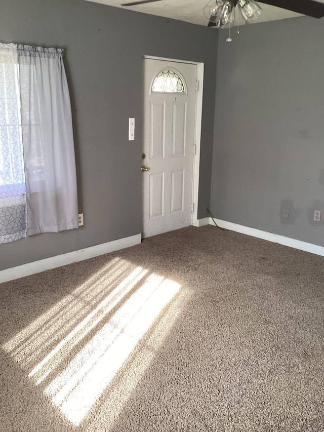 foyer with ceiling fan and carpet flooring