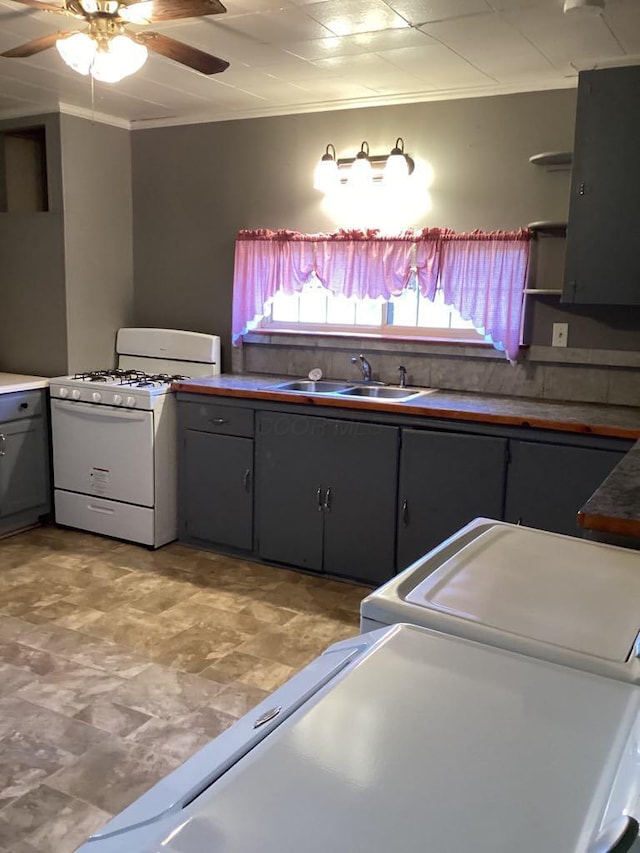 kitchen with ceiling fan, sink, crown molding, gray cabinetry, and white gas range