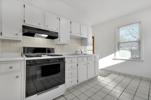 kitchen featuring light tile patterned floors, tasteful backsplash, gas range, white cabinets, and sink