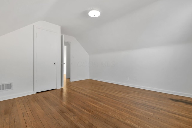 bonus room with hardwood / wood-style floors and vaulted ceiling