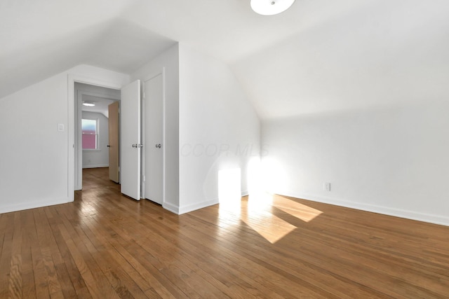 additional living space featuring hardwood / wood-style floors and vaulted ceiling