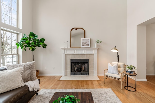 living room with hardwood / wood-style flooring and a tiled fireplace