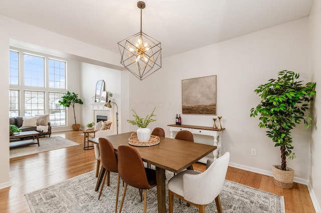 dining area featuring light wood-type flooring and a notable chandelier