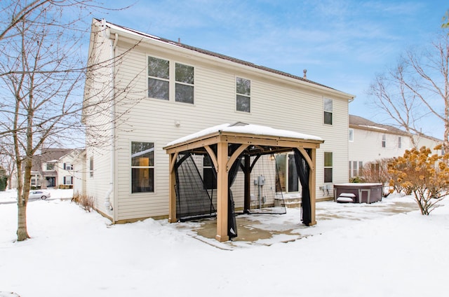 snow covered back of property with a gazebo