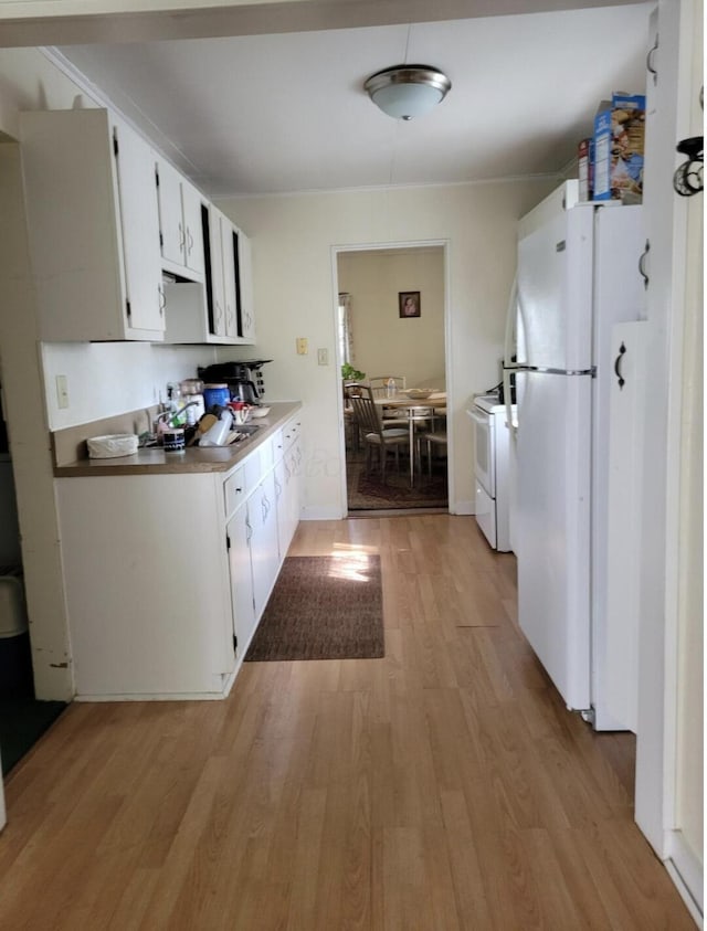 kitchen featuring white appliances, white cabinets, and light wood-type flooring