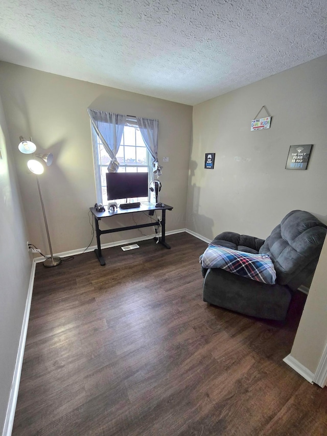 sitting room with a textured ceiling and dark hardwood / wood-style floors