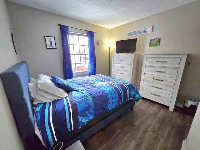 bedroom featuring a textured ceiling and dark hardwood / wood-style floors