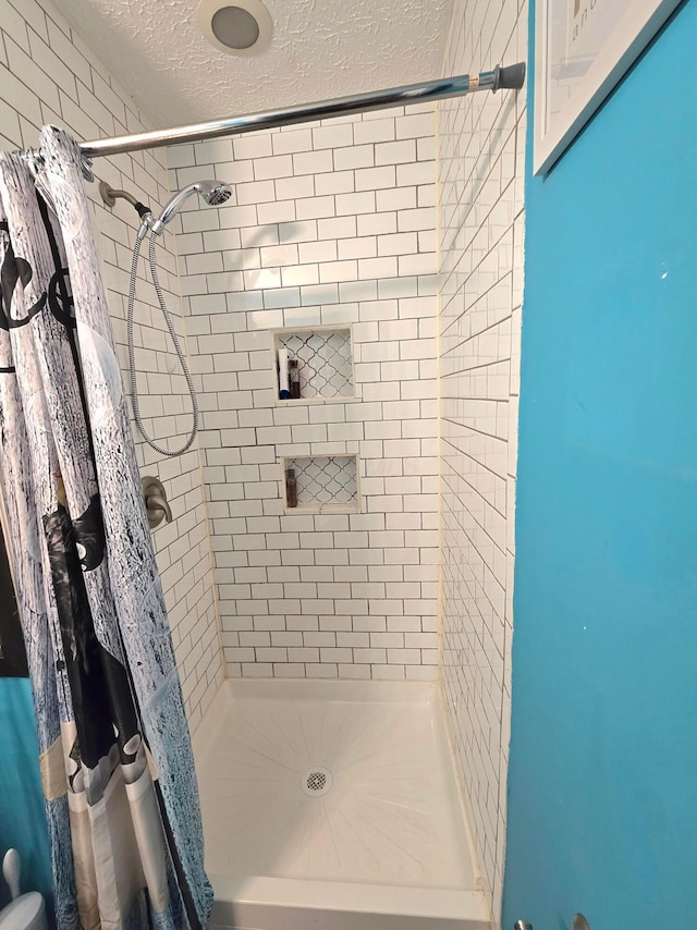 bathroom featuring a textured ceiling and curtained shower