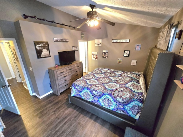 bedroom with vaulted ceiling, dark wood-type flooring, a textured ceiling, and ceiling fan