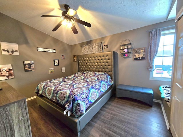 bedroom with ceiling fan, dark hardwood / wood-style flooring, lofted ceiling, and a textured ceiling