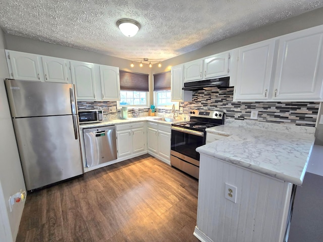 kitchen featuring stainless steel appliances, backsplash, and white cabinetry