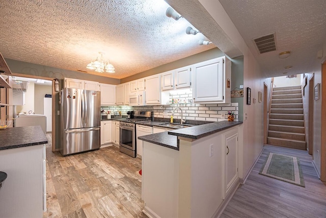 kitchen featuring sink, stainless steel appliances, and white cabinetry