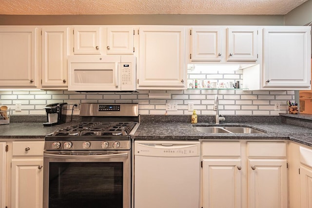 kitchen featuring white appliances, white cabinets, tasteful backsplash, and sink