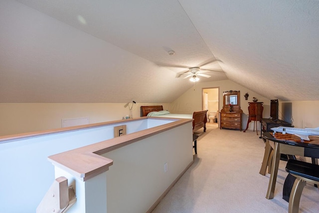 interior space featuring a textured ceiling, ceiling fan, and vaulted ceiling