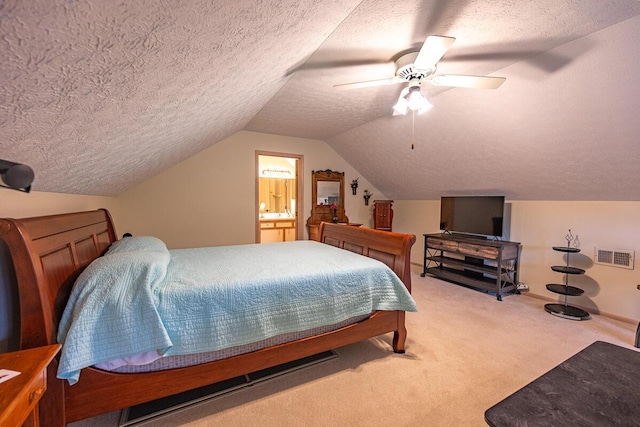 carpeted bedroom with ceiling fan, ensuite bath, lofted ceiling, and a textured ceiling