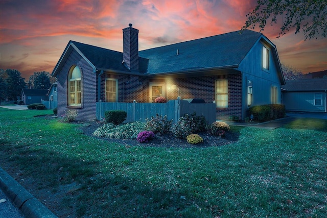 back house at dusk with a lawn