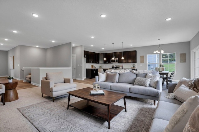 living room featuring baseboards, a chandelier, and recessed lighting