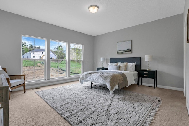 carpeted bedroom featuring visible vents and baseboards