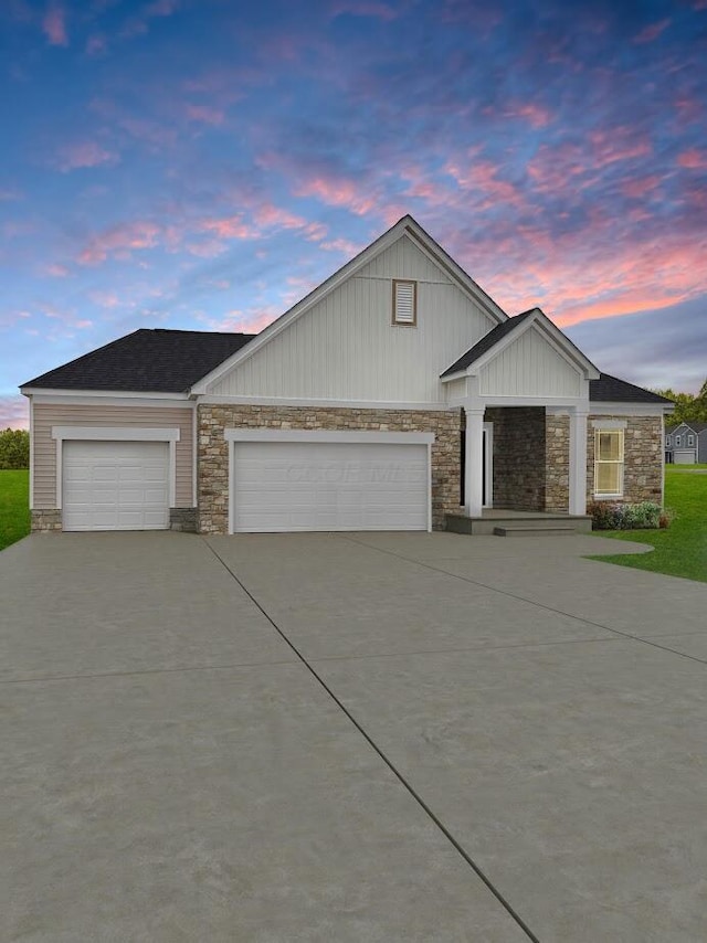 view of front facade featuring a garage, concrete driveway, and stone siding