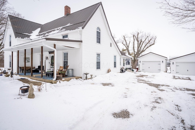 view of front facade with a garage, covered porch, and an outdoor structure