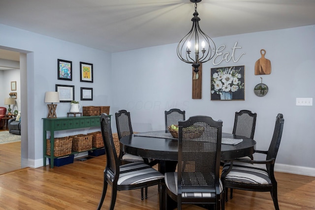 dining area featuring an inviting chandelier and light hardwood / wood-style floors