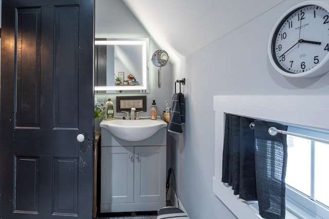 bathroom featuring lofted ceiling and vanity