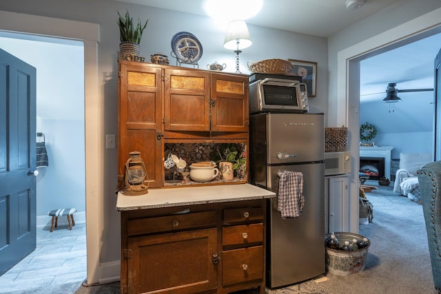 kitchen with stainless steel fridge, light colored carpet, and tasteful backsplash