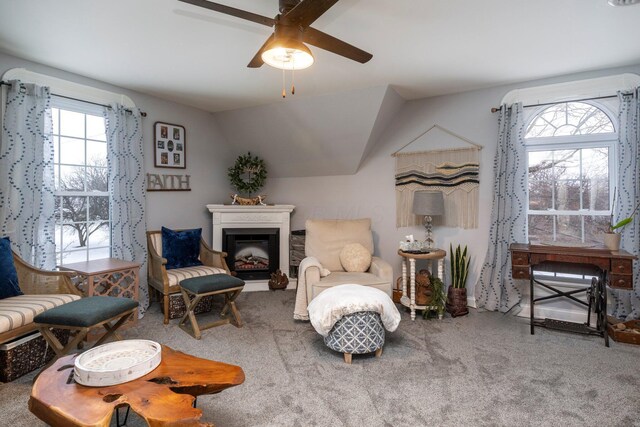 sitting room with ceiling fan, vaulted ceiling, a healthy amount of sunlight, and carpet