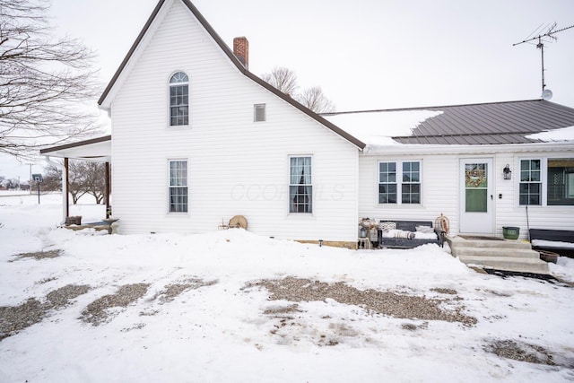 view of snow covered rear of property