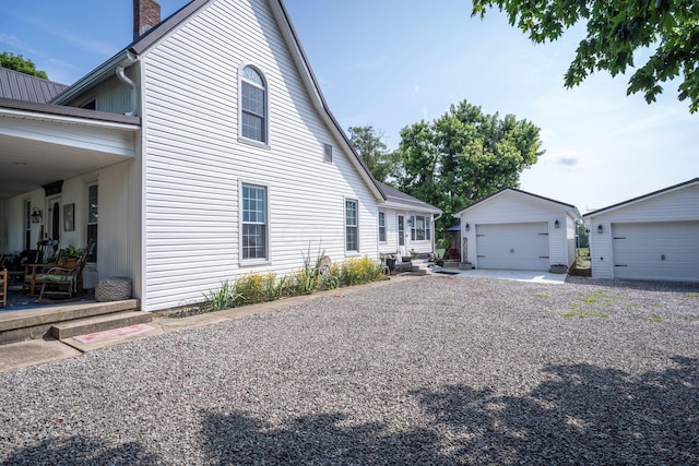 view of home's exterior with a garage and an outbuilding