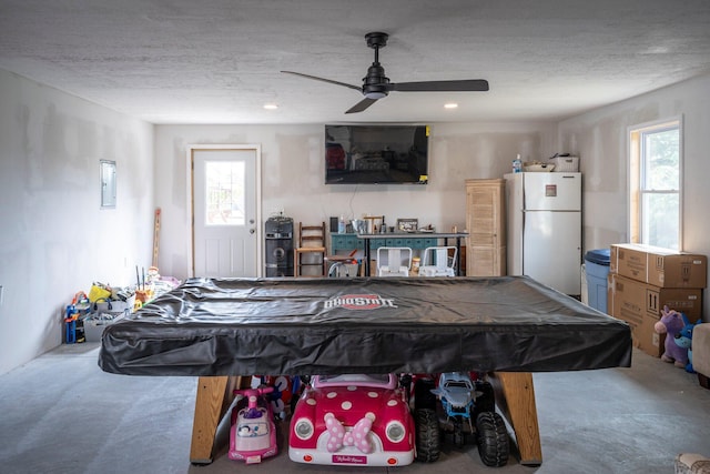 playroom featuring pool table, a textured ceiling, concrete floors, and a wealth of natural light